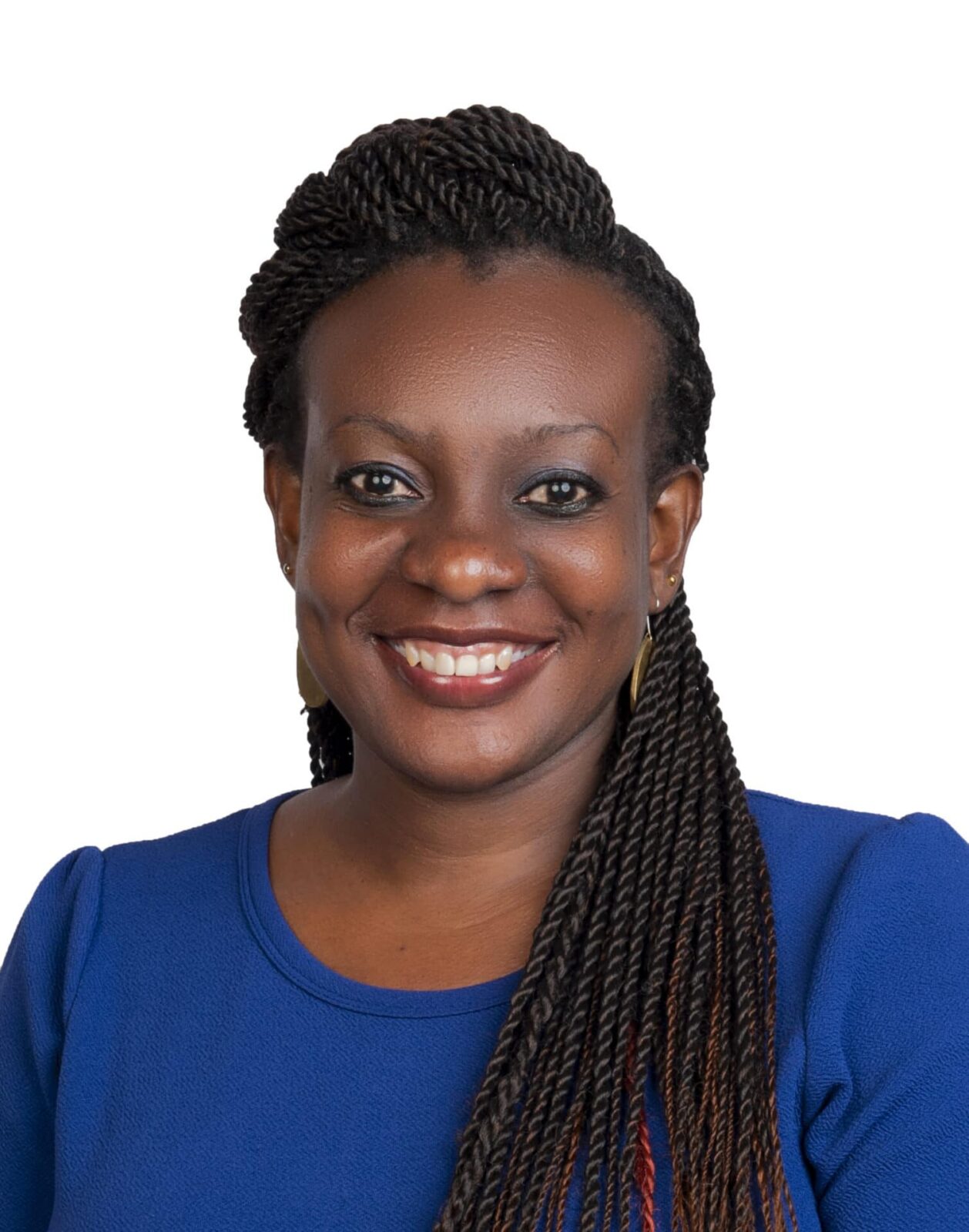 A woman with long braided hair wearing a blue top is smiling at the camera against a plain white background.
