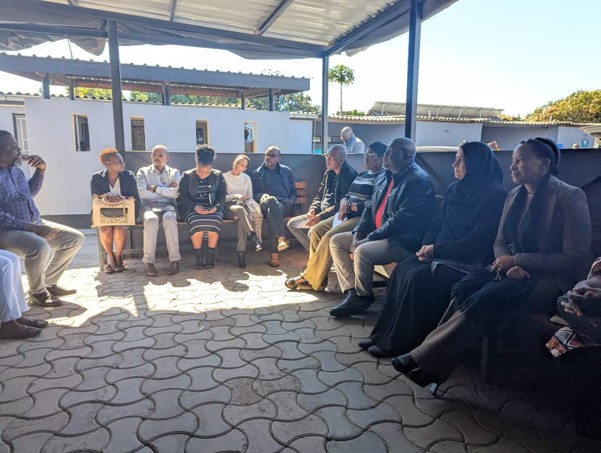 a group of people (delegation participants) standing in front of a hospital building 